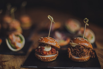 A close up shot of a selection of canape dishes. Concept of catering, hospitality and lifestyle. Small snacks and nibbles served on black slates for a private reception.