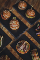 A close up shot of a selection of canape dishes. Concept of catering, hospitality and lifestyle. Small snacks and nibbles served on black slates for a private reception.
