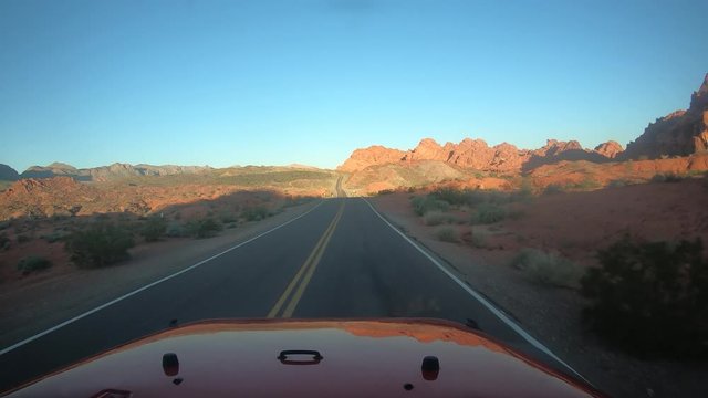 Driving Through Desert Road Surrounded by Rocky Landscape