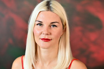 Naklejka premium Close-up portrait of a pretty caucasian woman with blond hair on a colored background. Great makeup, good facial skin.