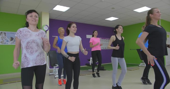 Group of women does warm up in gym