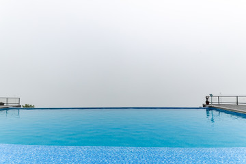 Obraz premium Infinity swimming pool with foggy white background