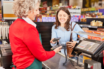 Kundin bezahlt kontaktlos mit NFC Smartphone