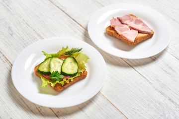 Sandwich with vegetables and a sandwich with meat. The choice between vegetarianism and meat-eating.