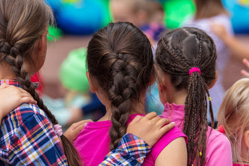 Hands on the shoulders of a girl with pigtails