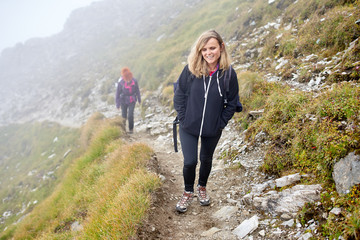 Naklejka na ściany i meble Backpacker ladies hiking on a trail