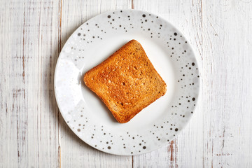 Fototapeta na wymiar Toasted white toast on a plate on a light wooden background.