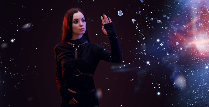 Portrait of mysterious sensual beautiful brunette woman in futuristic black dress on dark space magic background. Digital art. Augmented reality, dream, future technology, game concept. VR.