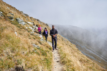 People with backpacks hiking into the mountains