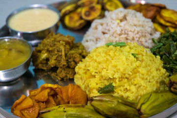 Indian Festve Foods. Traditional Bengali dishes for Indian Hindu Durga Puja or pooja festive food. A plate full of khichdi, pulao, curry, payesh and some fries.