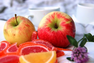 two red yellow Apples, colorful Apple marmalade slices and one flower of the clover. mini picnic in the Park