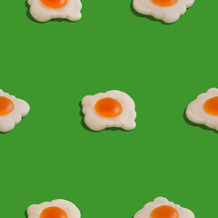 Creative seamless pattern with scrambled eggs on green background. Food abstract background