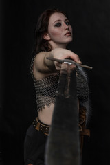 girl knight in chain mail with fur with a sword in her hands