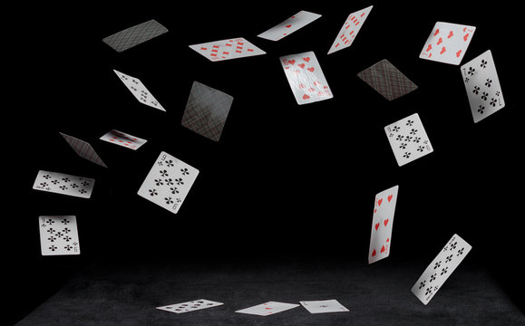 playing cards fall on a black table