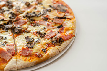 Freshly baked large pizza with ham, mushrooms and mozzarella on a traditional dough