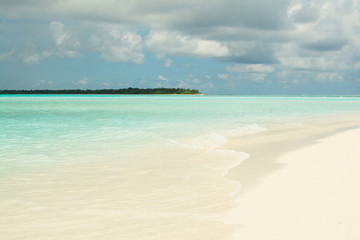 Beautiful tropical sandy beach with white sand and a gentle turquoise ocean in Maldives