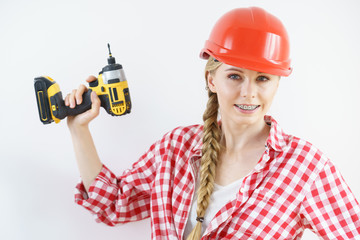 Woman wearing helmet using drill