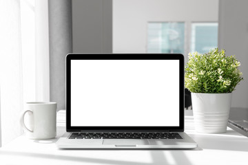 Computer,laptop with blank screen on table home, blurred background.