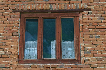 Altes Holzfenster mit Handgearbeitete Vorhänge verlassen.
