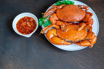Cooked crabs on white plate plate served , rusty metal  background, top view. copy space