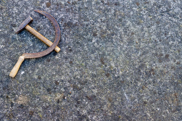Detail of an old concrete wall covered with lichens, with an old and rusty sickle and hammer. USSR symbol .Background. Vintage