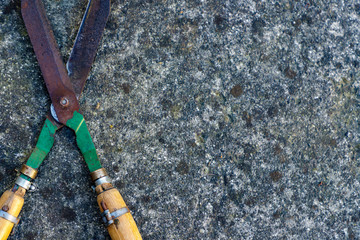 Detail of an old concrete wall covered with lichens, with old garden shears. Background. Vintage