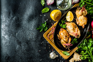 Delicious fried roasted quails with herbs, spices and greens. Grilled quails carcasses in a baking...