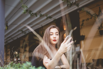 Elegant brunette with a cosmetic mirror in her hands