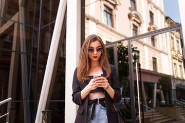 Girl uses a smartphone on a city street