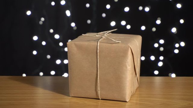 Caja de regalo en la mesa y fondo negro con luces