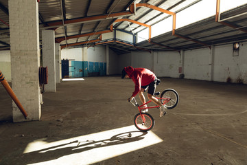 BMX rider in an empty warehouse