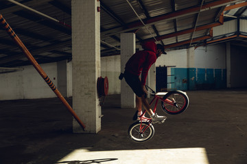 BMX rider jumping in an empty warehouse