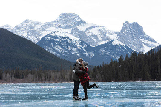 Couple kissing each other while standing in snowy landscape