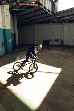 BMX rider in an empty warehouse