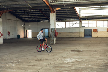 BMX rider in an empty warehouse