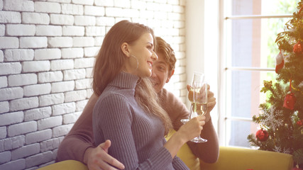 Lovely white couple hugging drinking champagne on Christmas day