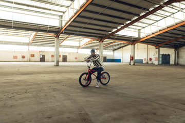 BMX rider in an empty warehouse