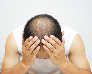 Fototapeta premium Stressed man with head in hands at home.