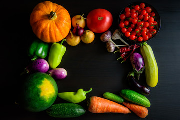 Thanksgiving day background with autumnal harvest on black wooden table. Detox, vegan and cleaning diet. Top view of fresh organic vegetables, close up.