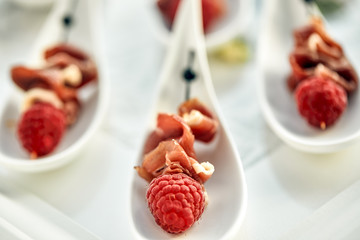 Delicious canapes hamon with raspberries. Concept of food, restaurant, catering, menu.