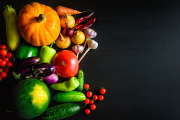 Tasty appetizing fresh autumn seasonal vegetables on dark wooden background top view with copy space. Healthy food, vegetarianism, clean eating. Harvest, gardening, Thanksgiving day concept.