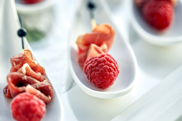 Delicious canapes hamon with raspberries. Concept of food, restaurant, catering, menu.