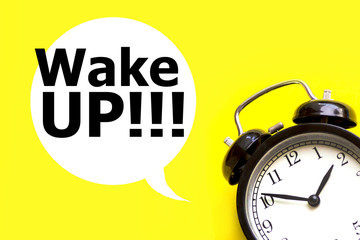 Alarm clock with text Wake up in bubble speech