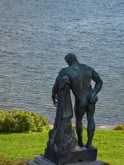 Statue of Hercules from the back against the water. Catherine park. Russia.
