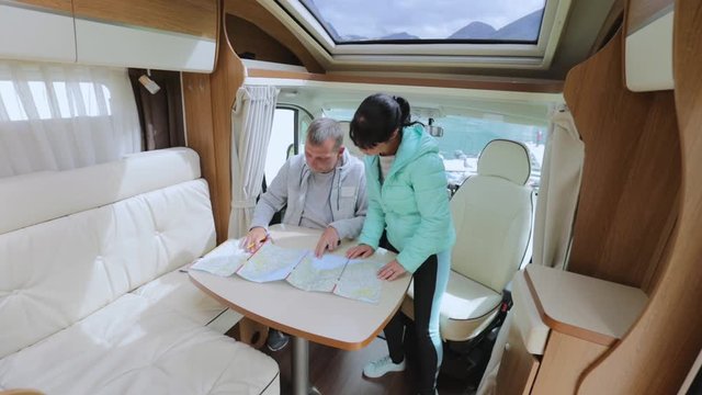 Couples in RV Camper looking at the local map for the trip.