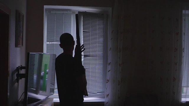 man with gun, looking through the window. bodyguard and self defense concept, otherwise robber, murderer and thief concept