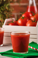 Tasty Tomato juice in a glass with ripe red tomatoes.