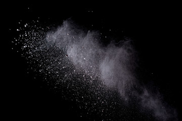 Freeze motion of white color powder exploding on dark background. 