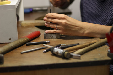 A jewelry master is working to create a silver ring