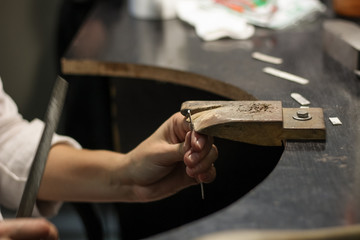 A jewelry master is working to create a silver ring